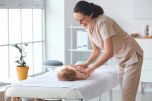 Vrouw geeft baby een ontspannende massage.